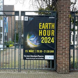 Ein Banner am Rathaus weist auf die Earth Hour 2024 hin.